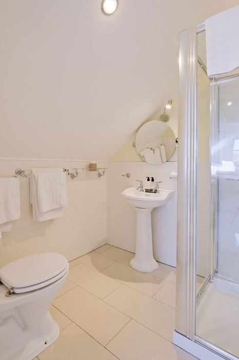 Dormer ensuite bathroom with round mirror