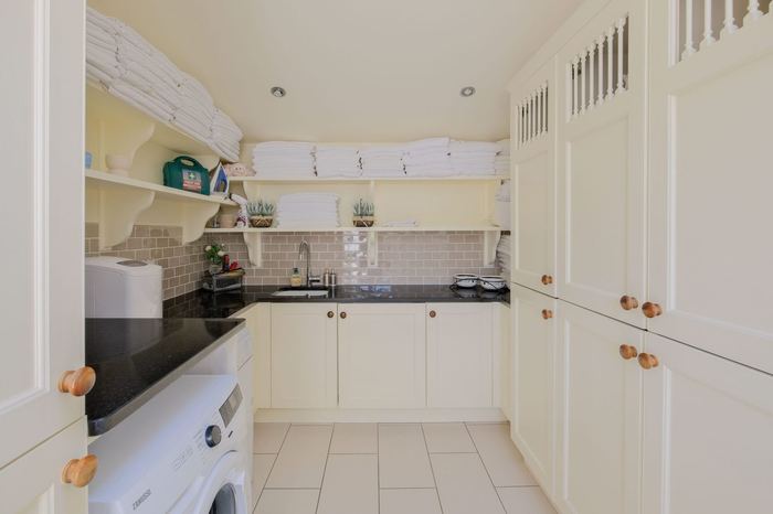 Utility room with washer and linen storage