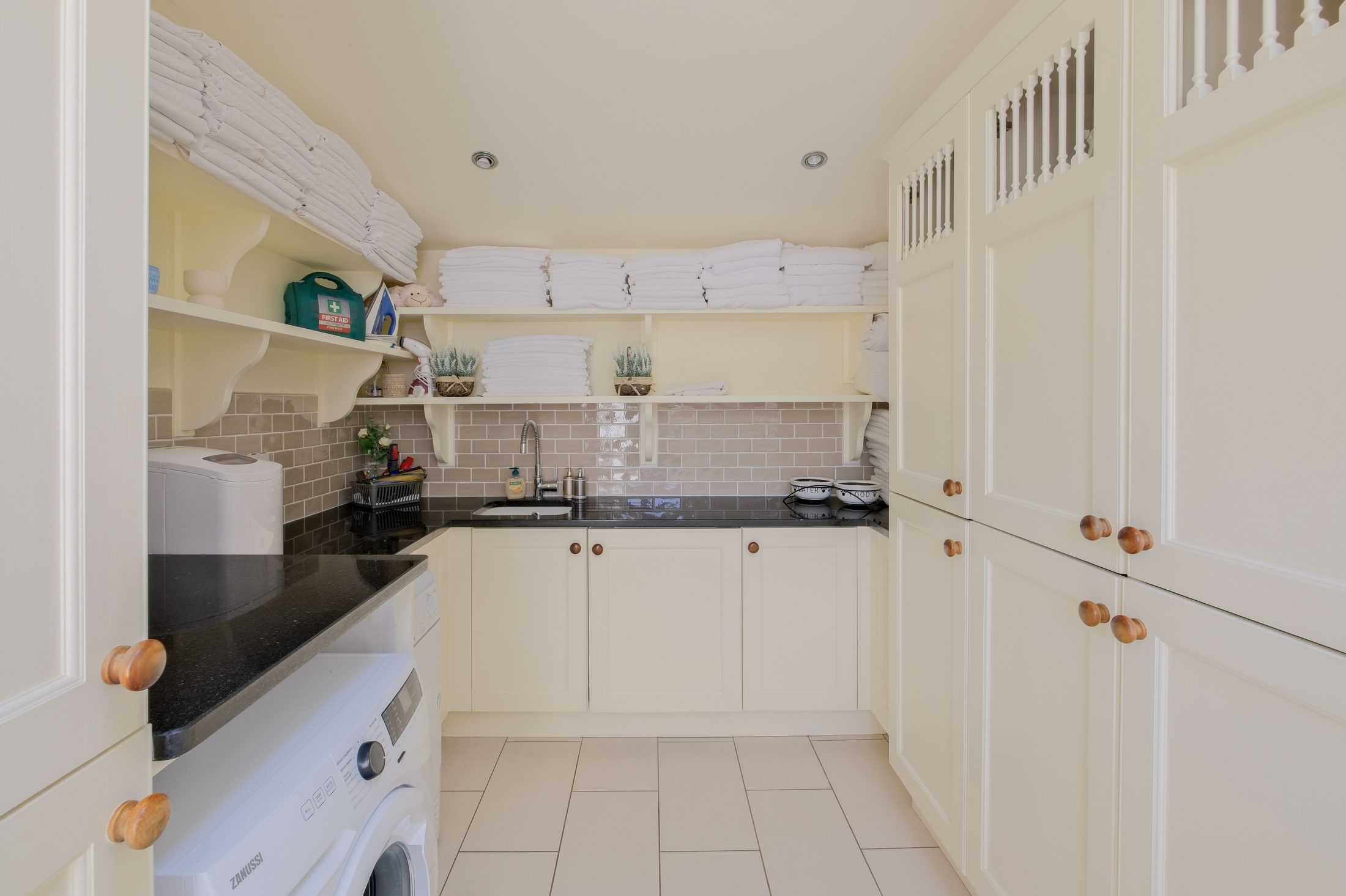Utility room with washer, dryer, and linen storage